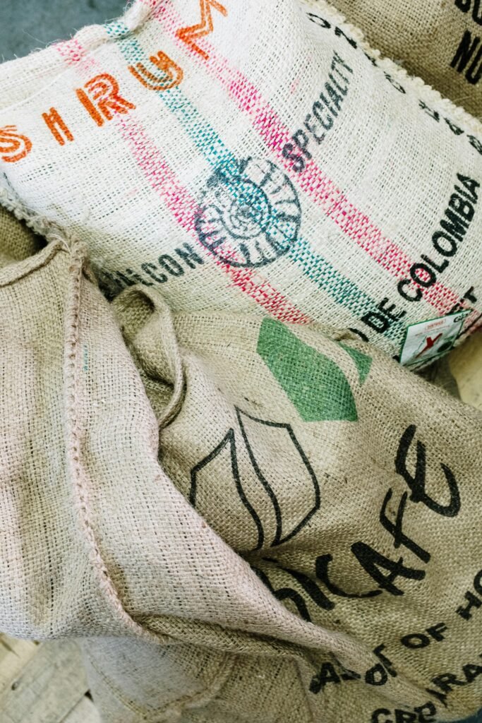 Close-up of burlap sacks for organic coffee beans in a roastery setting.